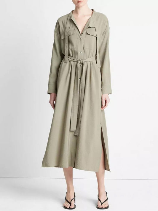 A woman wearing a Vince Soft Utility Shirt Dress in Sea Fern and black heeled sandals made from responsible materials.