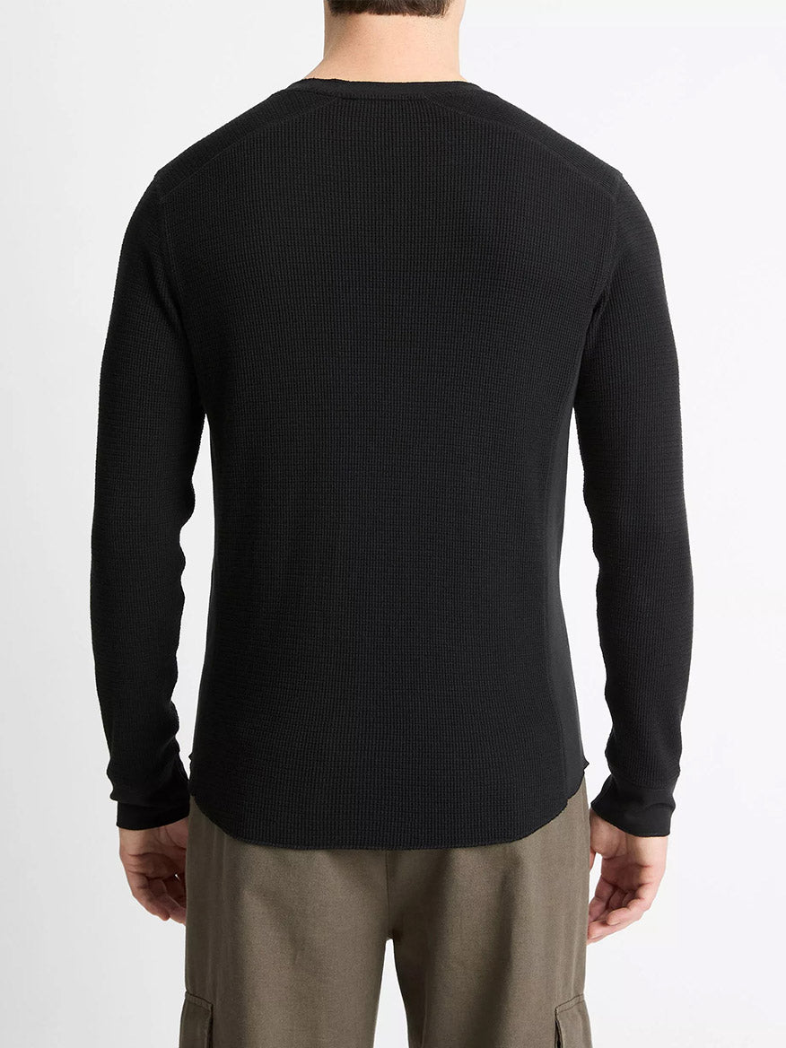Someone wearing the Vince Pima Cotton-Blend Thermal Long-Sleeve Pullover in black and brown pants, shown from behind against a plain white background.