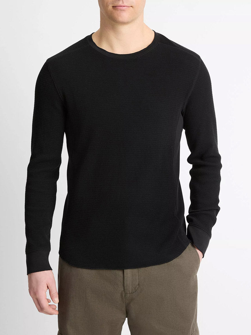 A man wearing the Vince Pima Cotton-Blend Thermal Long-Sleeve Pullover in black and olive green pants stands against a plain white background.