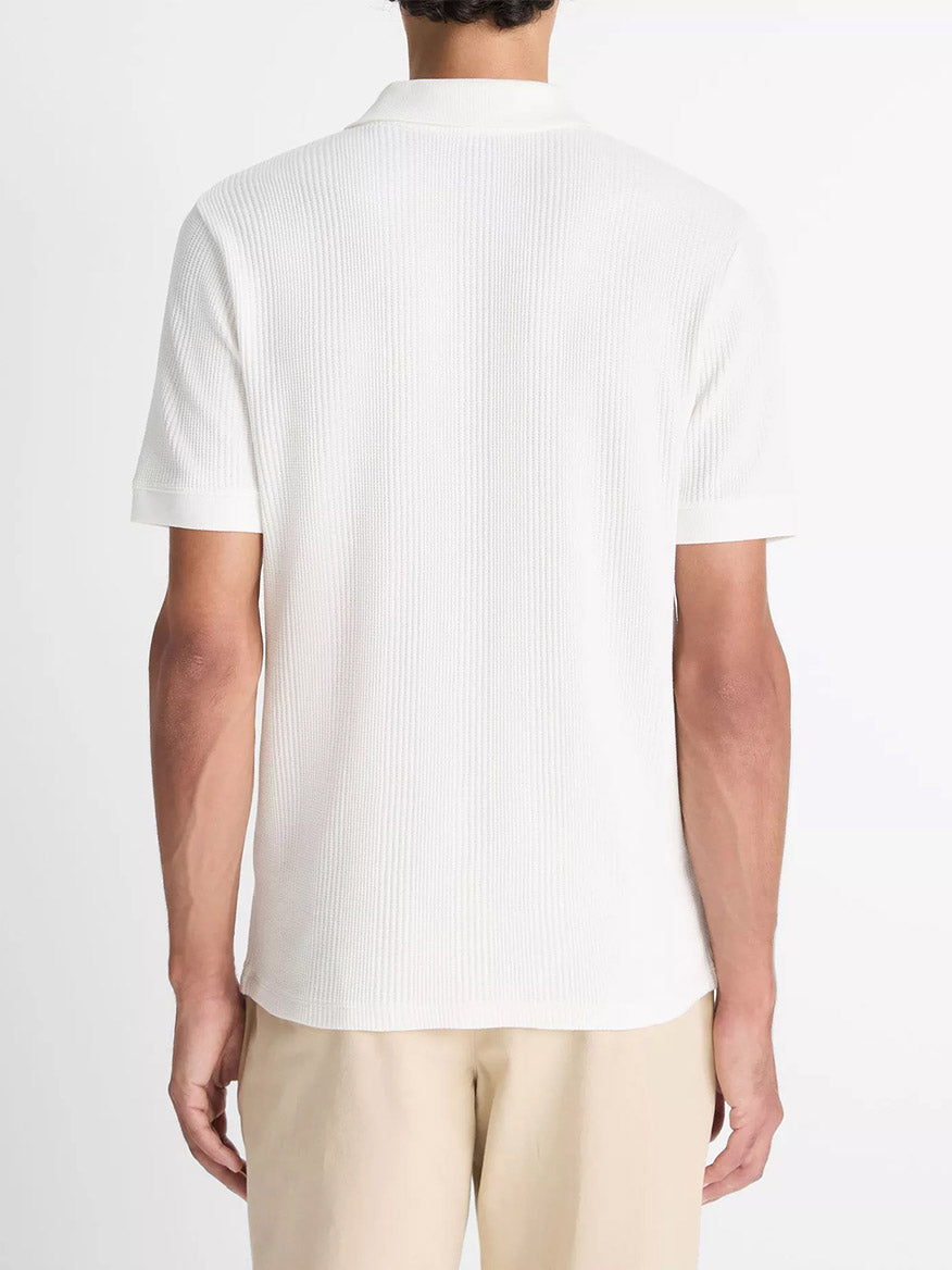 A person is shown from the back wearing the Vince Variegated Pima Cotton Polo Shirt in Off White and beige pants against a plain background.