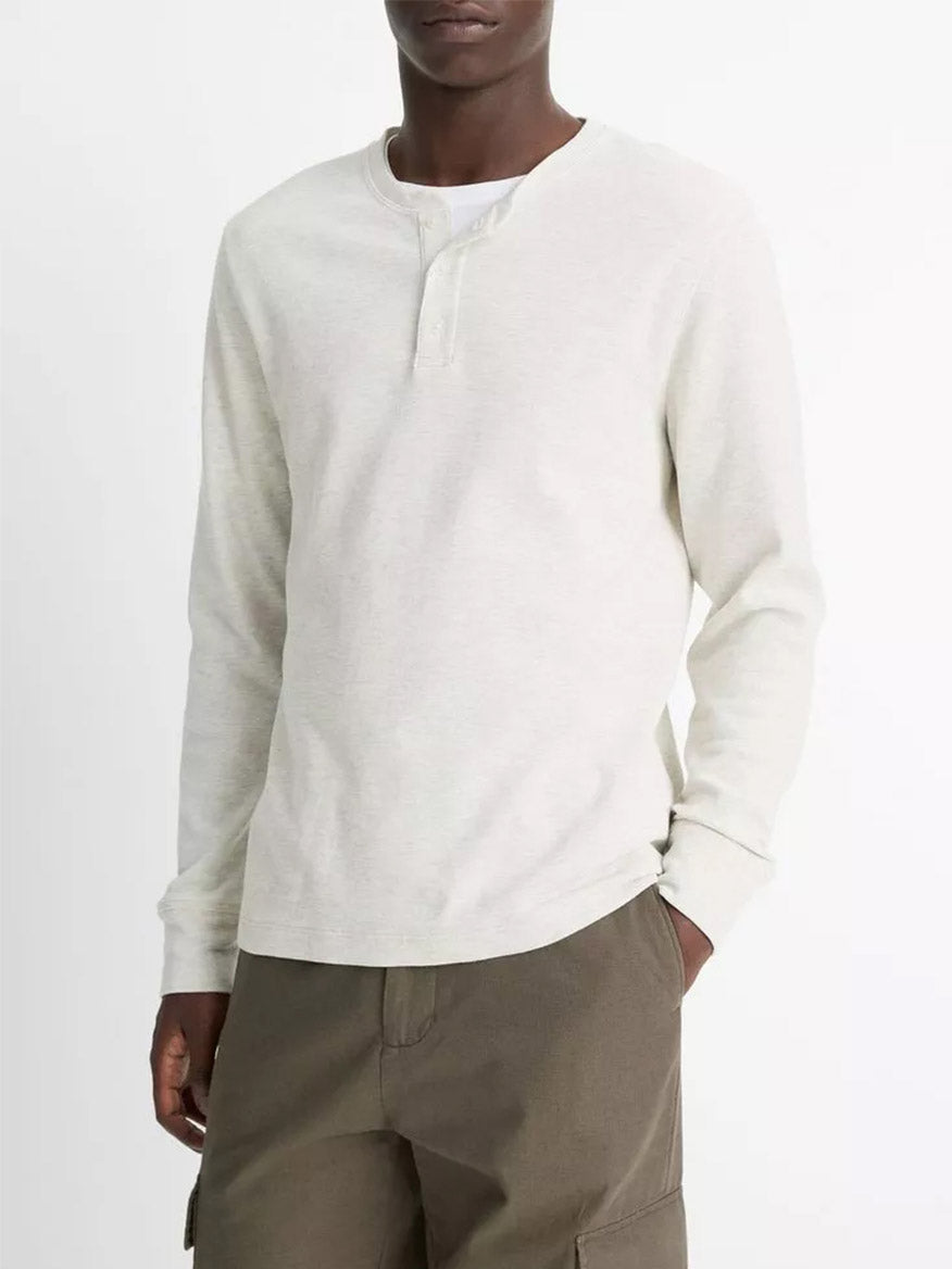 A person wears the Vince Pima Cotton Waffle Henley in Heather Baja Sand with olive green cargo pants, standing against a plain white background.