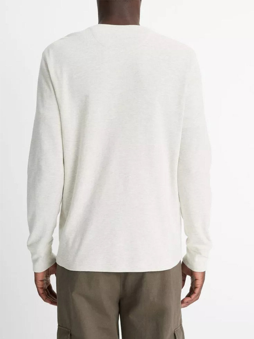A person is shown from the back against a plain background, wearing the Vince Pima Cotton Waffle Henley in Heather Baja Sand and olive-green cargo pants.