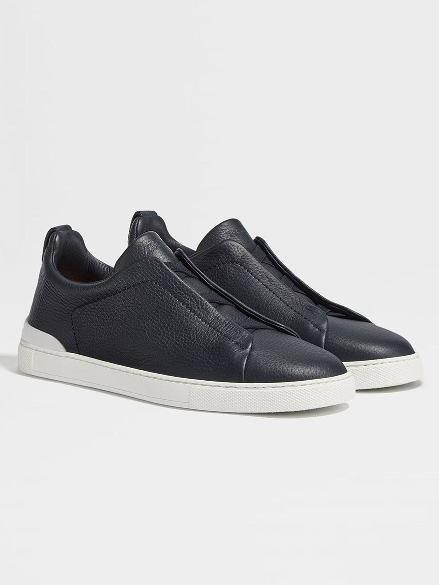 A pair of Zegna Navy Blue Deerskin Triple Stitch™ Sneakers with white rubber soles is displayed against a plain light background.
