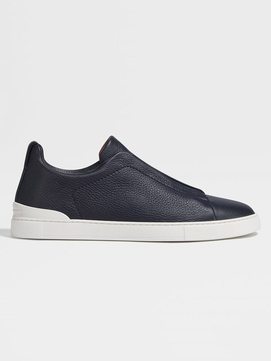 A single navy blue ZEGNA Triple Stitch™ deerskin sneaker with a white rubber sole, displayed on a plain white background.