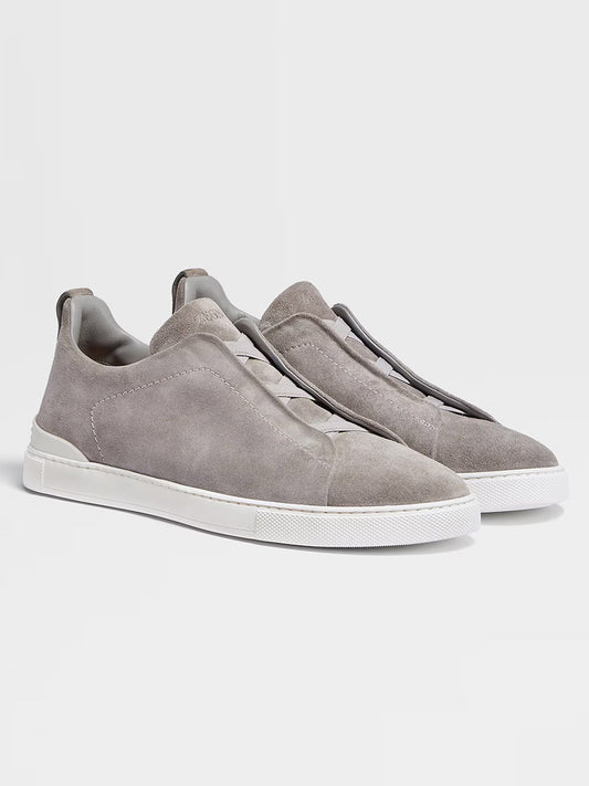 Zegna Light Grey Suede Triple Stitch™ Sneakers feature lightweight suede and white rubber soles, displayed against a plain light background to highlight their fine craftsmanship and timeless style.