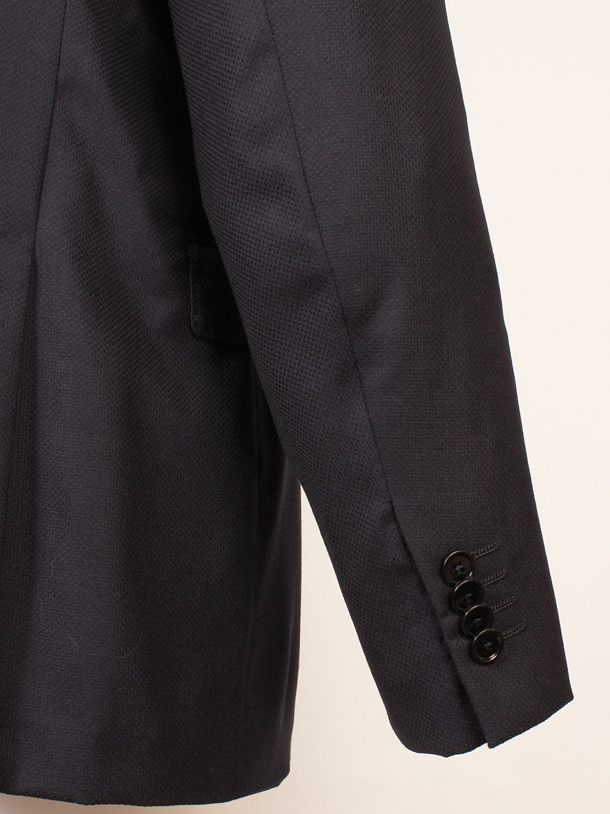 Close-up of a Zegna Navy Trofeo Comfort Wool Blazer sleeve featuring four black cuff buttons and a slanted pocket in the background.
