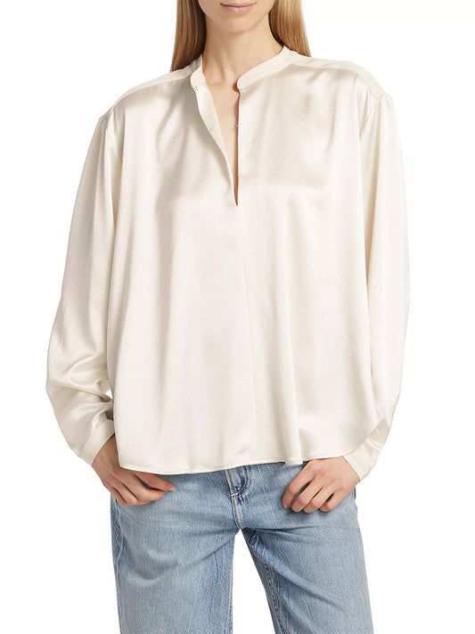 Woman wearing a rag & bone Rosie Keyhole Blouse in Ivory with a stand collar, paired with blue jeans, standing against a neutral background.