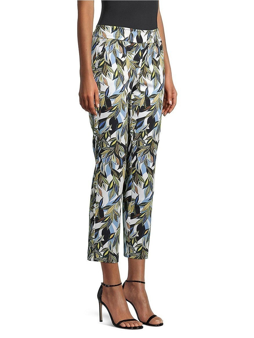 Woman in slim fit Avenue Montaigne Lulu Leaf Print Pant in Amazing Blue Multi and black heels standing against a white background.
