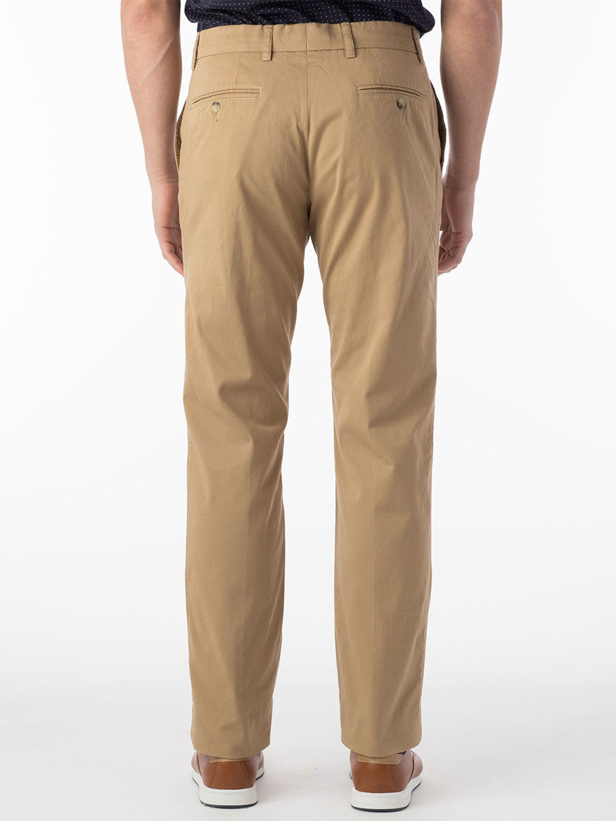 An individual dressed in the Ballin Atwater True Khaki Modern Flat Front Pant in British Tan and brown shoes is standing with their back to the camera, radiating exceptional comfort.