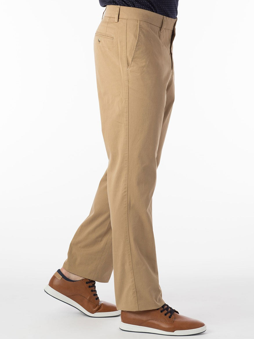 A person is wearing the Ballin Atwater True Khaki Modern Flat Front Pant in British Tan and brown shoes with white soles, standing on a white background, exuding an air of exceptional comfort.