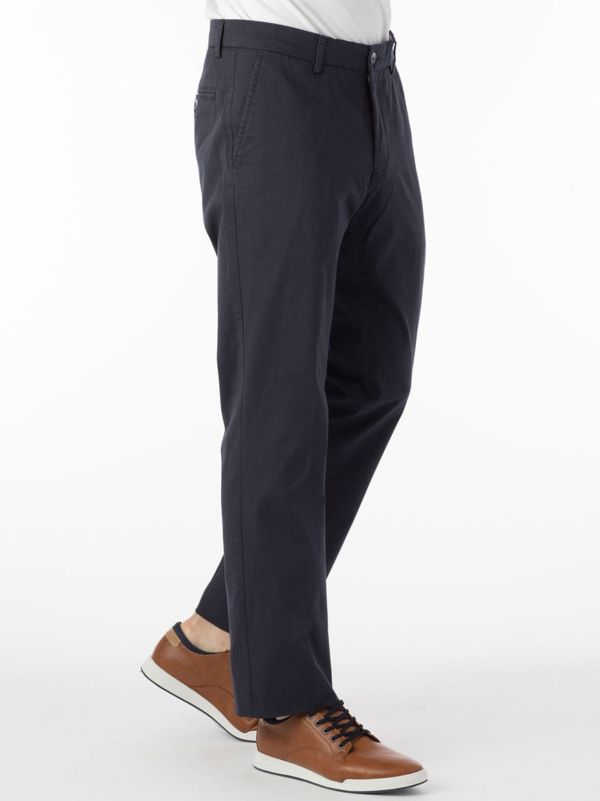 A person wearing Ballin Atwater True Khaki Modern Flat Front Pant in Navy, made from lightweight stretch Pima cotton, and brown casual shoes with white soles. The image is cropped above the waist and the person is standing on one leg.
