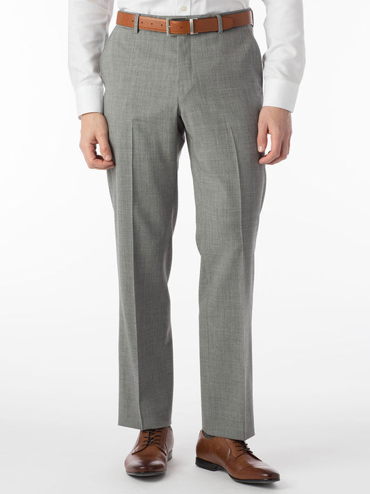 A person wearing Ballin Soho Comfort 'EZE' Super 120s Modern Flat Front Twill Pant in Pearl Grey, a white shirt, brown belt, and brown dress shoes stands against a plain white background.
