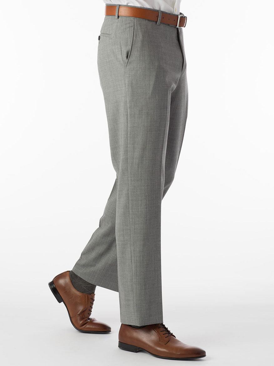 A person wearing Ballin Soho Comfort 'EZE' Super 120s Modern Flat Front Twill Pant in Pearl Grey, paired with a brown belt and brown dress shoes, stands against a white background.