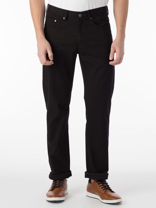 A man wearing Ballin Crescent Modern 5 Pocket Twill Pants in Black jeans and a white pima cotton t-shirt.