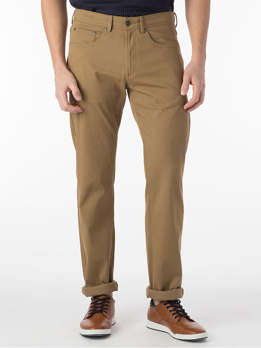 A man donning Ballin Crescent Modern 5 Pocket Twill Pants in British Tan, providing exceptional comfort, paired with a sleek black shirt.