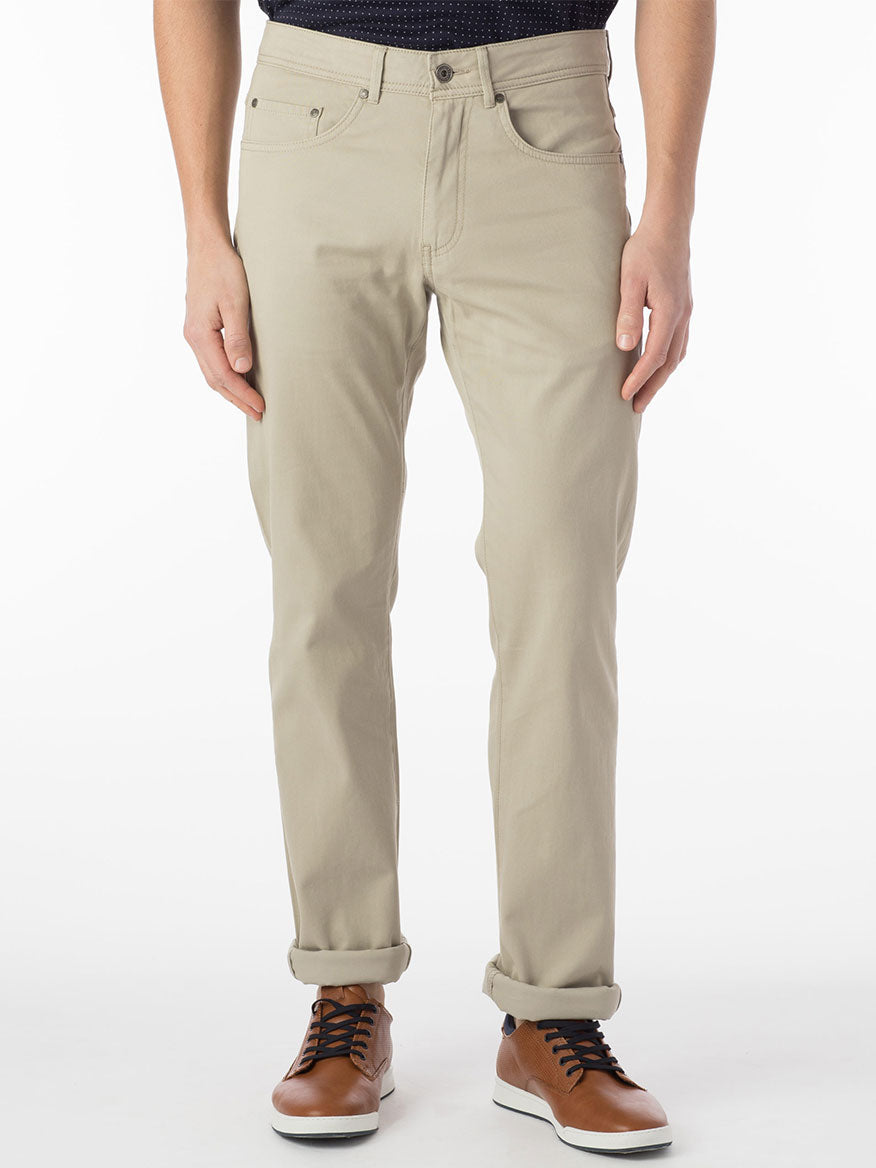 A man wearing the Ballin Crescent Modern 5 Pocket Twill Pants in Stone, made of premium stretch twill fabric, paired with a black shirt.