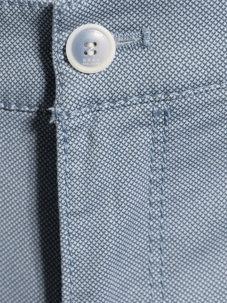 Close-up of a button on Brax Bari Triplestone Printed Modern Fit Short in Smoke Blue Bermuda shorts with visible stitching and fabric weave.