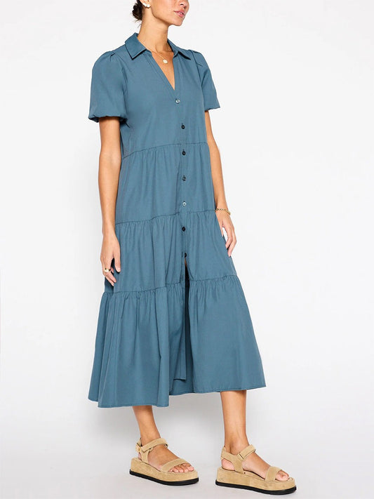 Woman modeling a versatile mid-length Brochu Walker Havana Dress in Ocean with short sleeves, button-up front, and tiered skirt, showcasing its feminine appeal and paired with casual sandals.