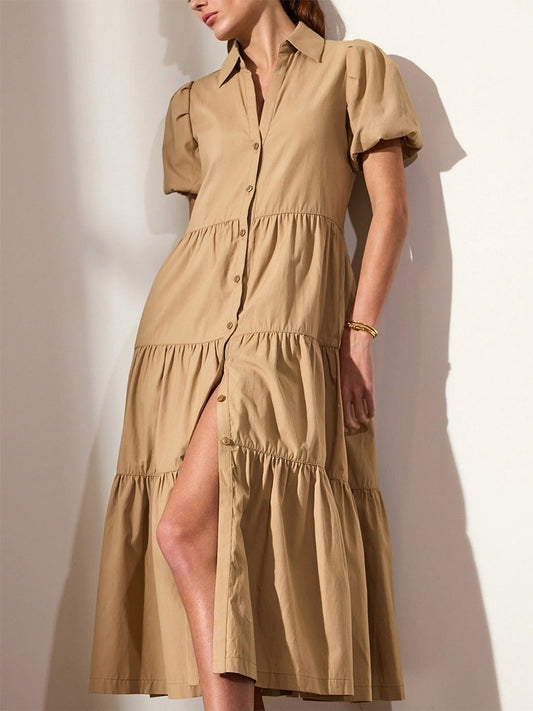 A woman in a Brochu Walker Havana Dress in Sahara with puff sleeves and a tiered skirt, exuding feminine appeal against a neutral background.