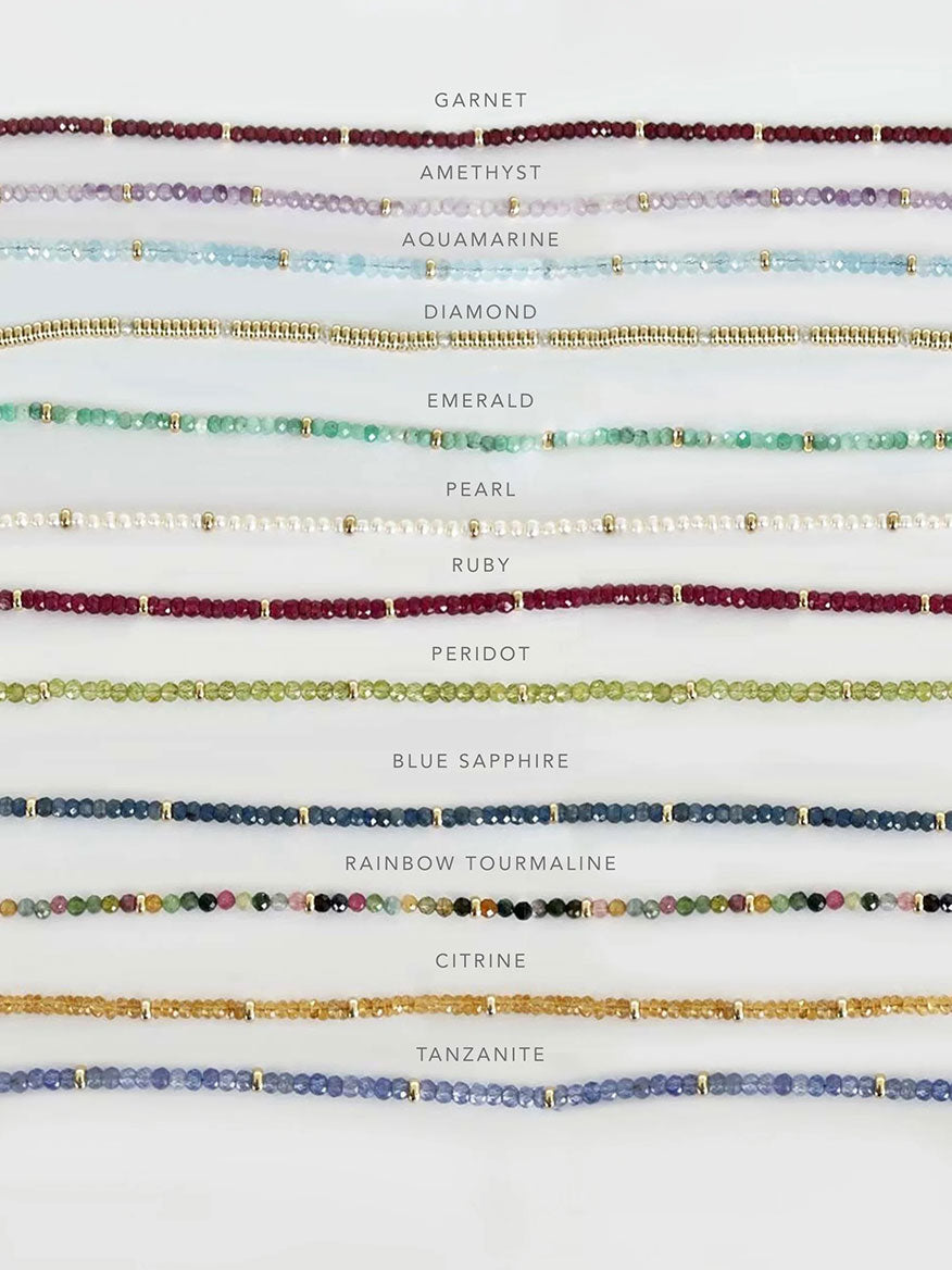 An EF Collection Birthstone Necklace with Gold Rondelles - Tanzanite featuring a variety of bracelets with different colors of beads, made from natural stones. Perfect for necklace layering.