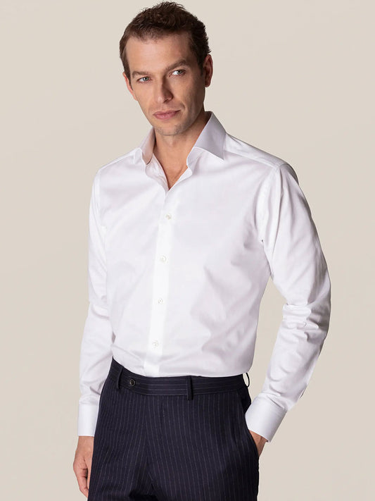 Man posing in an Eton Contemporary Fit White Stretch Twill dress shirt and pinstripe trousers.