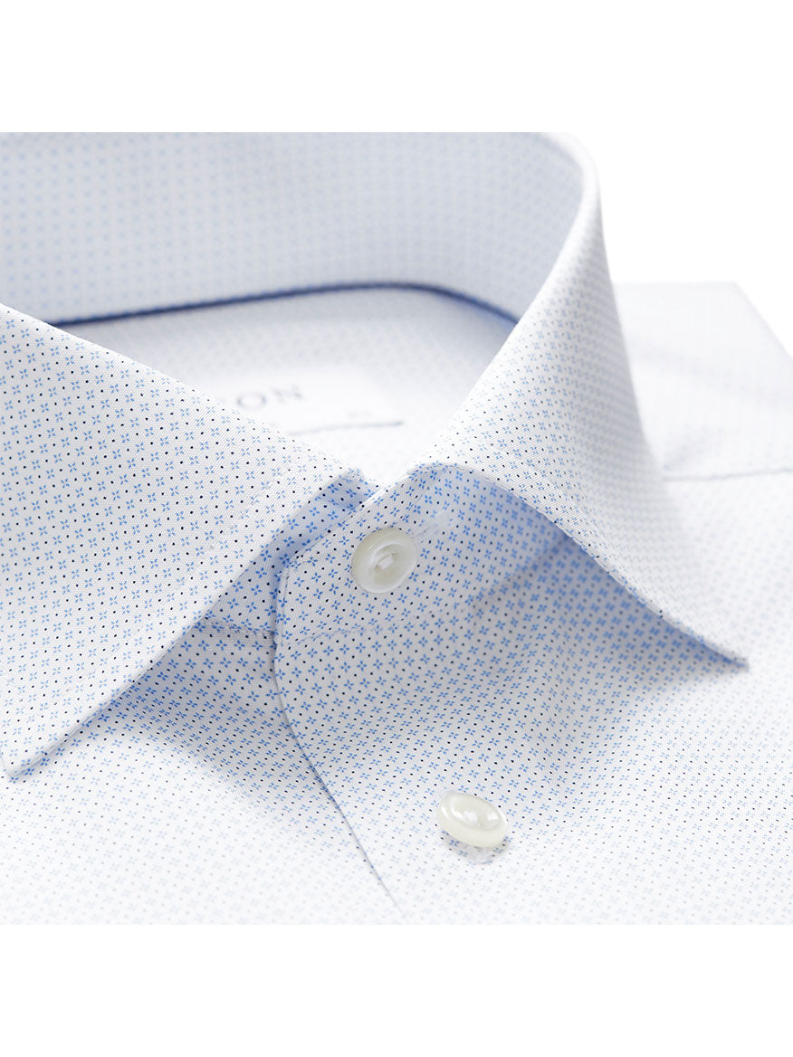 Close-up of a light blue, patterned dress shirt with a pointed collar and two visible buttons, showcasing the Eton Contemporary Fit Sky Blue Micro Print Dress Shirt for a timeless wardrobe staple.