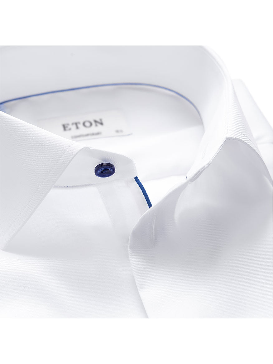 Close-up of a white Eton Contemporary Fit dress shirt collar with a blue button, featuring navy details.