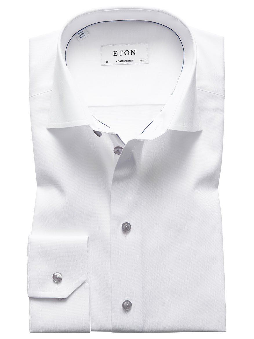 A neatly folded Eton Contemporary Fit White Twill Dress Shirt with grey details, featuring a visible label printed with the word "ETON," showcasing the collar and buttons.