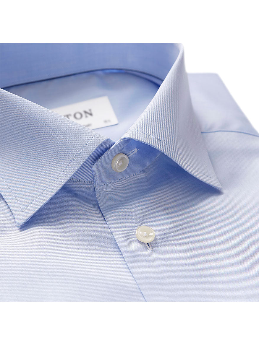 Close-up of a light blue Eton Contemporary Fit Light Blue French Cuff Dress Shirt with the top button undone, revealing a white label on the collar.