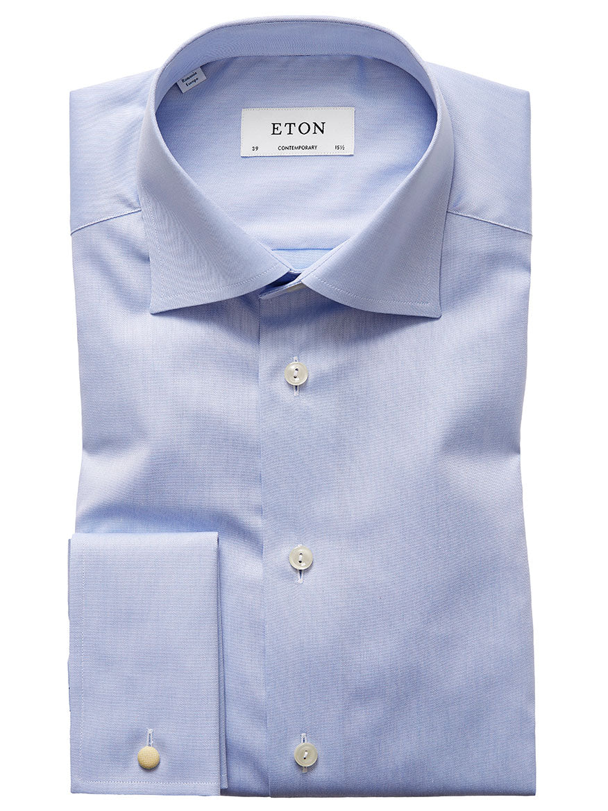 A neatly folded, wrinkle-free Eton Contemporary Fit Light Blue French Cuff Dress Shirt with a label displaying "ETON" and size details. The shirt features a pointed collar, French cuffs, and is buttoned down the front.
