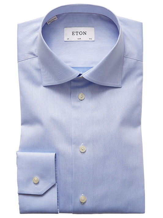 A folded light blue, wrinkle-free Eton Slim Fit Signature Twill Dress Shirt with a spread collar, button cuffs, and white buttons. The inside collar label reads "ETON." This versatile shirt is perfect for any occasion.