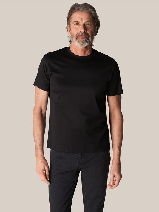 Mature man modeling a comfortable, black Eton Filo di Scozia T-shirt made from top-quality fabric.