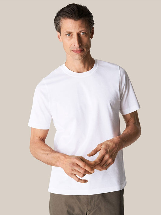 Man in luxurious Eton Filo di Scozia white t-shirt standing against a neutral background.