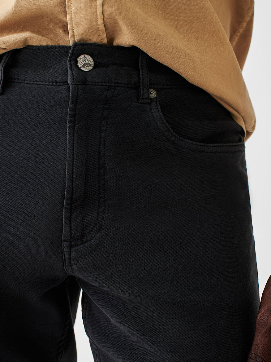 A man is wearing Faherty Brand Stretch Terry 5-Pocket Pant in Onyx.