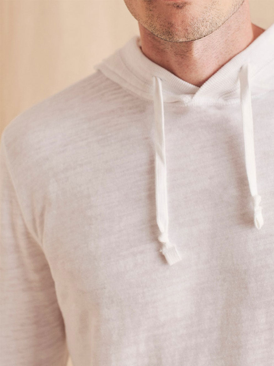 A man wearing a Faherty Brand Slub Cotton Hoodie in White made of organic cotton.