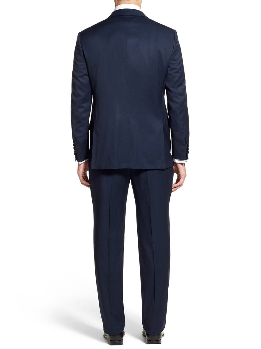 Rear view of a man in a navy suit standing, showcasing the elegant peak lapel of his Hickey Freeman (Heritage Gold) Navy Tasmanian Wool Tuxedo.