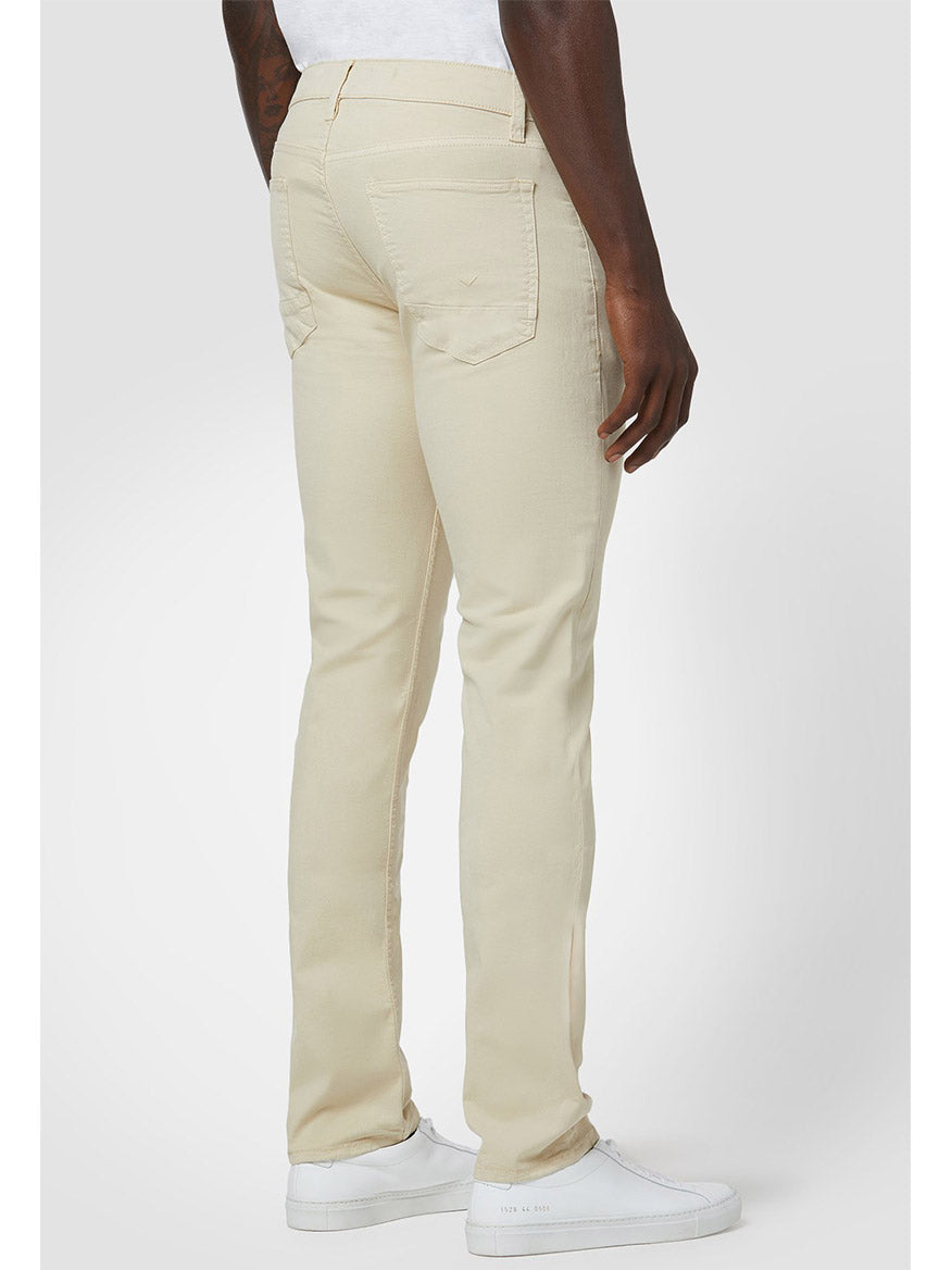 Rear view of a person wearing Hudson Blake Slim Straight Twill Pant in Light Beige cargo pants and white sneakers, standing against a plain background.