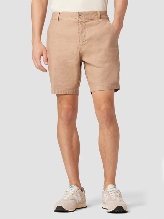 Man standing in Hudson Chino Shorts in Latte and sneakers.