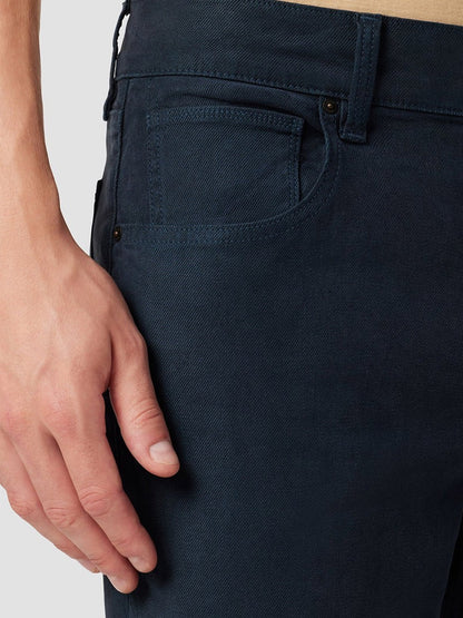 Close-up of a person's hand tucked in the pocket of Hudson Blake Slim Straight Twill Pants in Night Blue wash, emphasizing the fabric and stitching details.