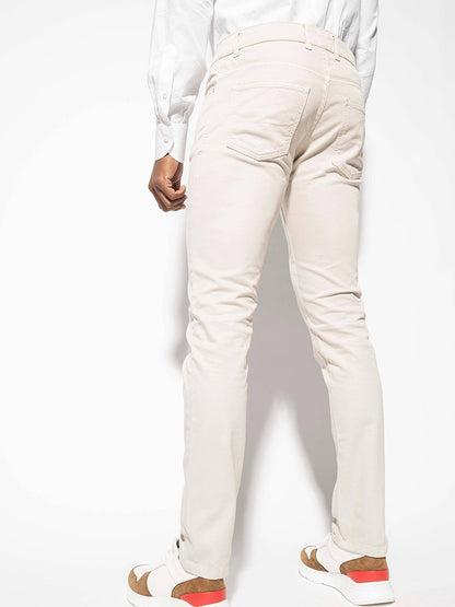 A man wearing a white shirt and beige pants in Isaia Slim Straight 5-Pocket Denim in Stone.