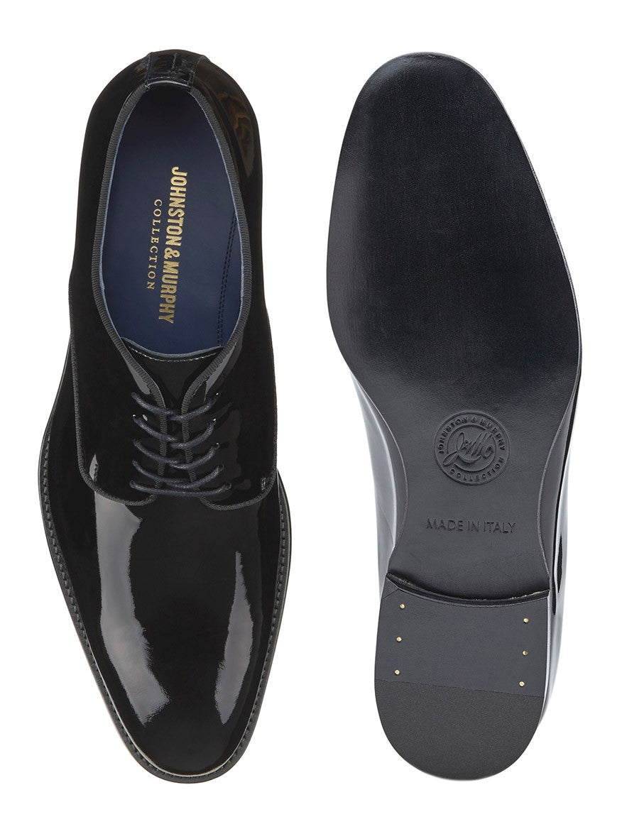 Pair of J & M Collection Kinser Plain Toe in Black Italian Patent Calfskin. One shoe is shown from the top, with laces visible, and the other is shown from the bottom, displaying "Made in Italy" text and brand name on the sole. The Italian upper complements a luxurious leather lining for ultimate comfort.