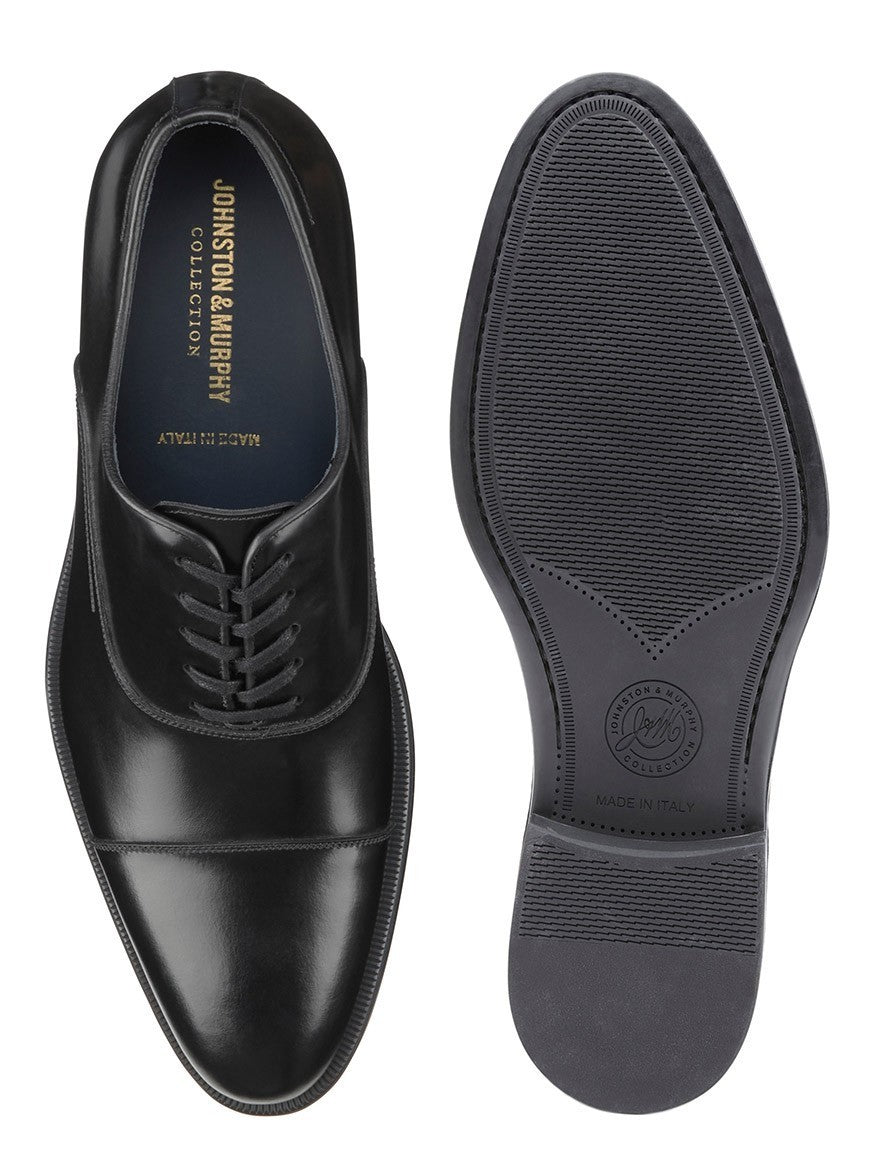 A pair of J & M Collection Flynch Cap Toe in Black Italian Calfskin derby shoes on a white background.