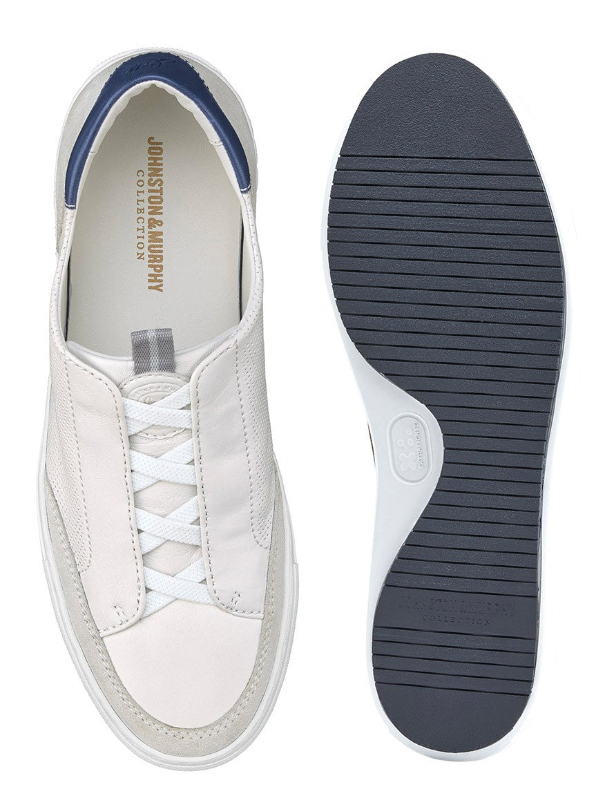 A pair of J & M Collection Anson Stretch Lace-to-Toe White English Suede/Sheepskin sneakers with blue soles featuring cushioning and a leather lining.