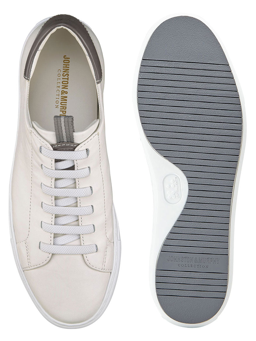 A pair of J & M Collection Anson Lace-to-Toe sneakers in white sheepskin with grey trim. The left shoe is shown from the top, while the right highlights the grey, ridged flexible EVA sole, ensuring modern cushioning for ultimate comfort.