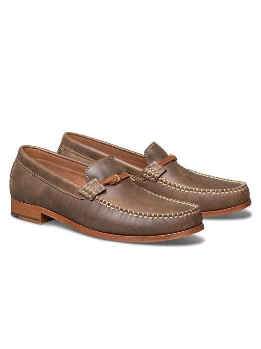 A pair of J & M Collection Baldwin Leather Bit in Brown American Full Grain men's loafers with tassels and decorative stitching on a white background.
