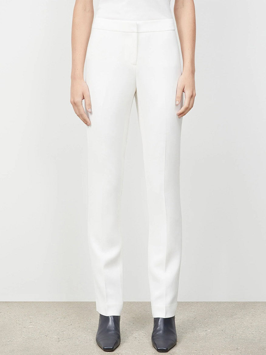A person standing against a plain background, wearing white Lafayette 148 New York Finesse Crepe Barrow Pant in Cloud with black shoes. The person is shown from the shoulders down, showcasing expert tailoring.