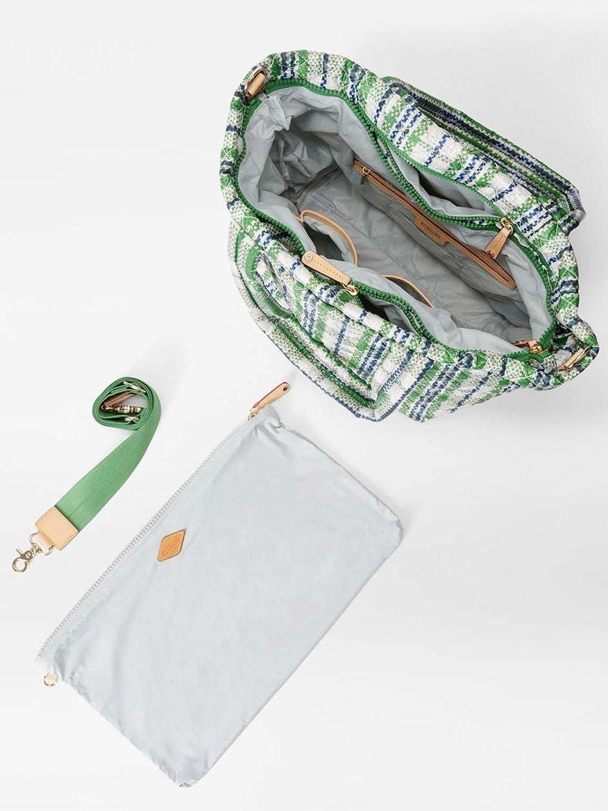 Open green and white woven MZ Wallace Medium Metro Tote Deluxe in Spring Plaid Oxford with a gray inner lining beside a matching detachable strap and a gray zippered pouch on a white background.
