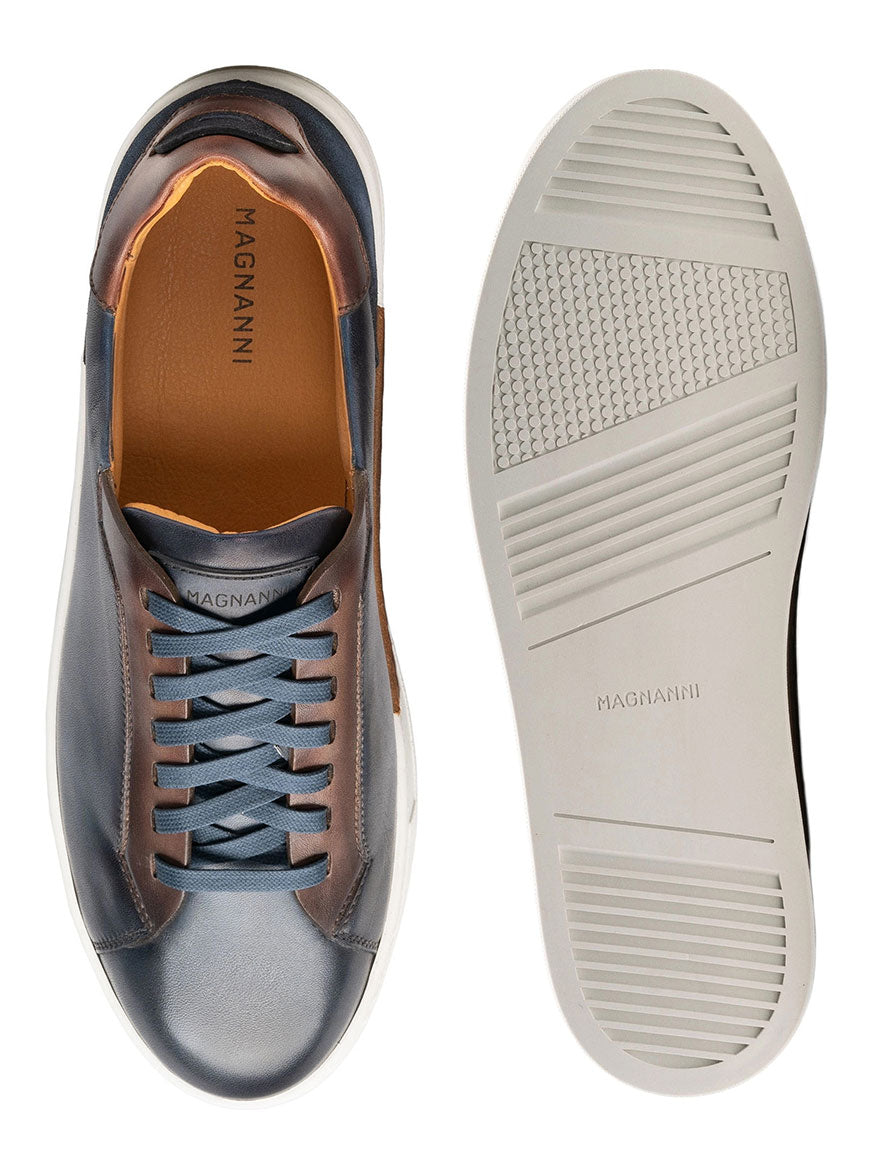 A pair of Magnanni Amadeo in Navy & Brown luxury sneakers with a contemporary cupsole, featuring blue and brown soles.