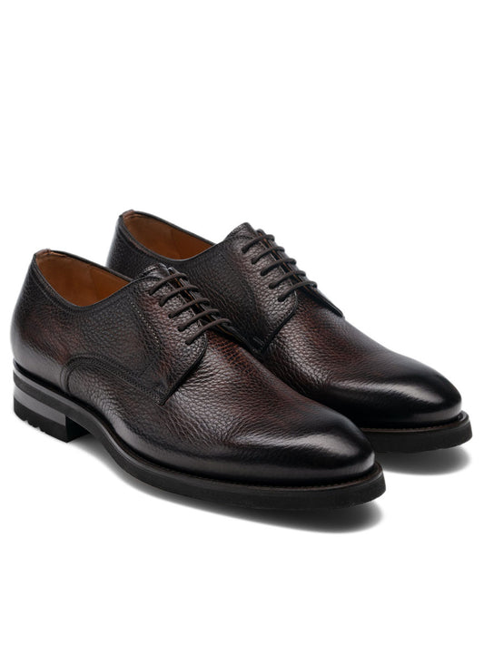 Magnanni Melich II in Brown: a pair of dark brown leather dress shoes with laces and low stacked heels, expertly handcrafted in Spain and shown against a plain white background.