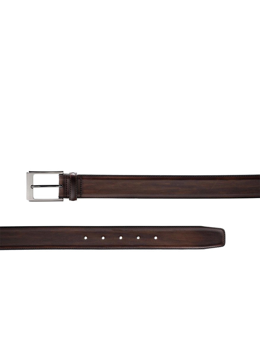 A Magnanni Vega Belt in Tabaco, crafted from dark brown calfskin leather and featuring a polished nickel buckle, is displayed horizontally against a white background. The belt, exhibiting a luxurious patina, includes several holes for adjustment.